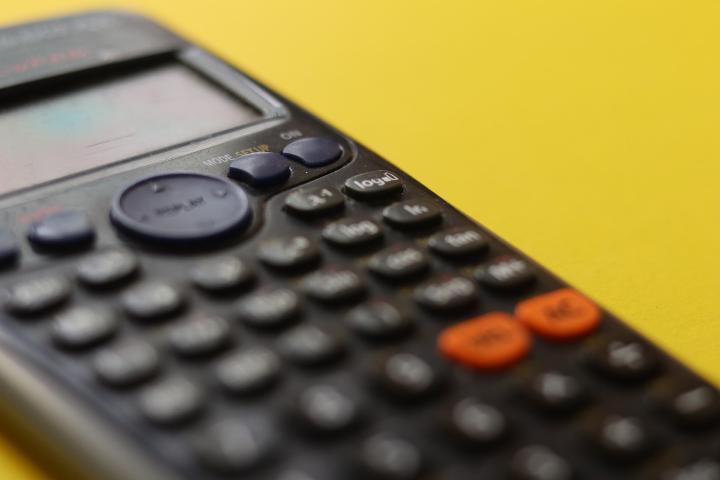 A calculator is used to calculate business cost.
