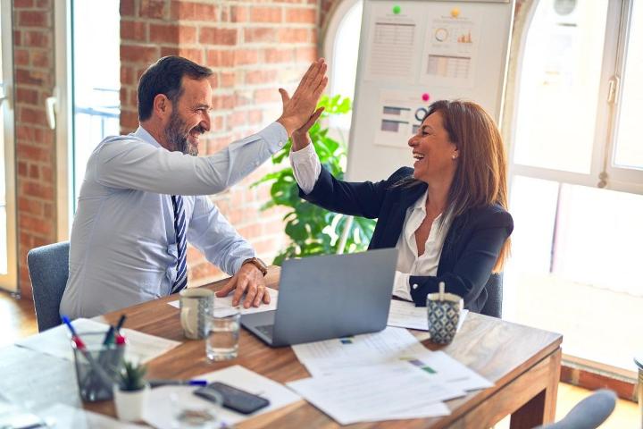 A man and woman is high-five to each other.